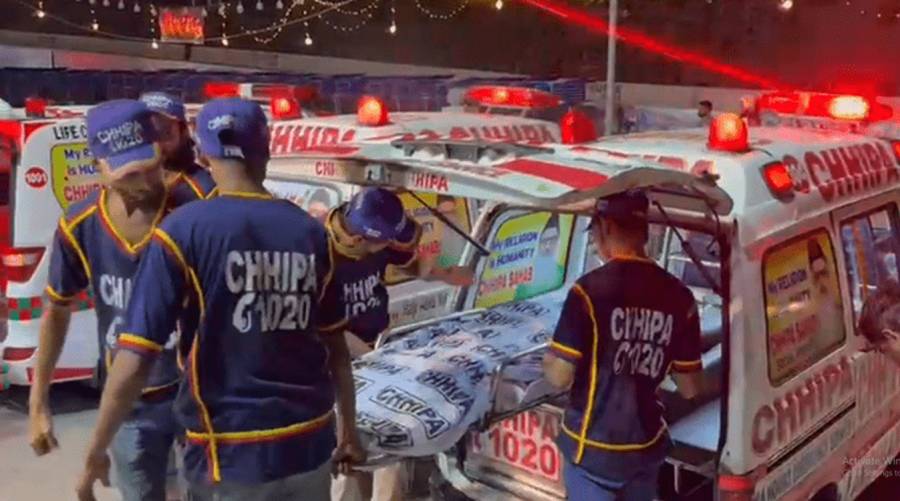 Rescue officials at the scene of a fatal road accident in Karachi, where a couple lost their lives.
