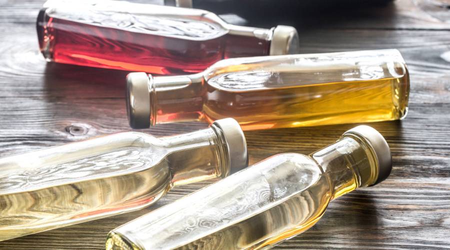 Bottles of apple cider vinegar laying on a wooden floor