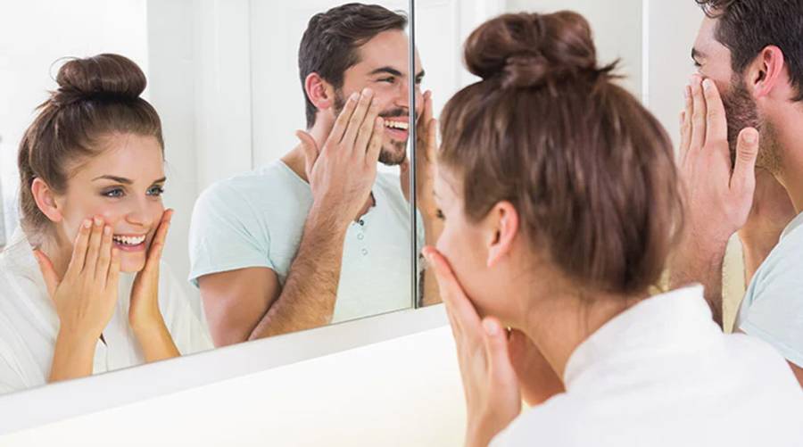 Woman and a man applying sunscreen on their face as part of daily skin care routine