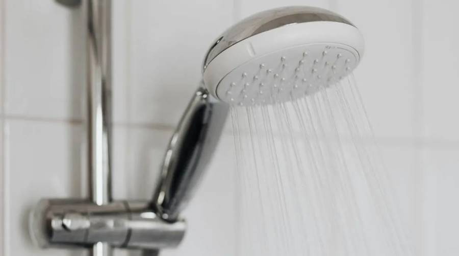 A close-up image of a sleek shower tap with water flowing, representing the concept of choosing between morning and night showers.
