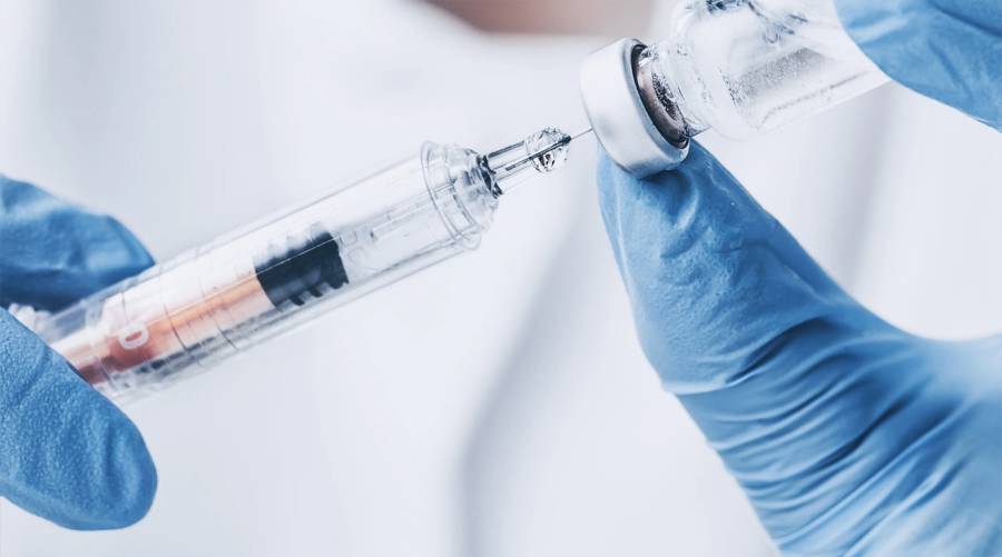 Nurse giving MMR vaccine to child during 2025 measles outbreak.