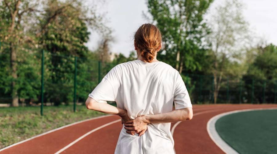 A woman walking outdoors to relieve back pain, based on new scientific research findings.