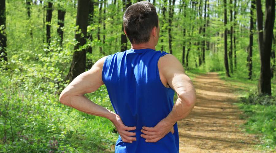 Woman walking outdoors to prevent back pain naturally