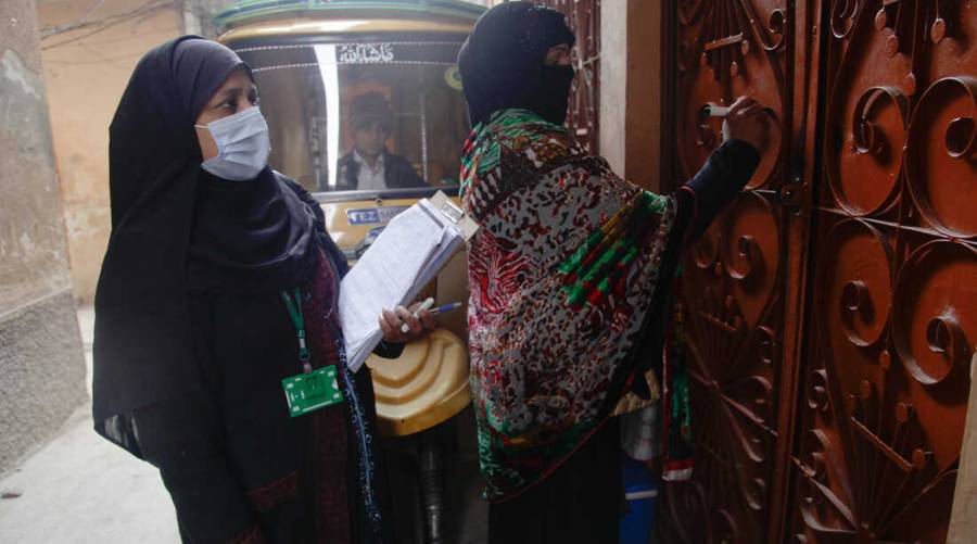 File photo of two Pakistani lady health workers marking a house door during a polio vaccination campaign