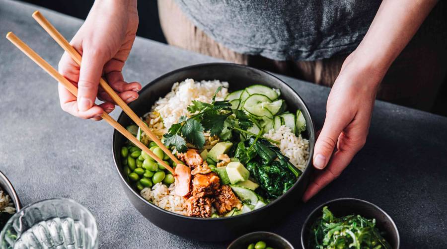 Woman eating dinner late in the evening in dim lighting, highlighting potential blood sugar risks