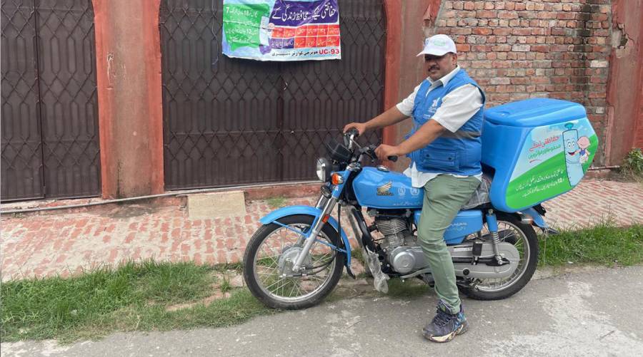 WHO-supported vaccinator on motorbike in Pakistan’s high-priority district, enhancing vaccine access to underserved children