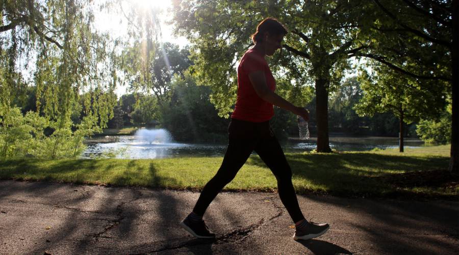Person enjoying a brisk walk outdoors to improve heart health and reduce cardiovascular disease risk.