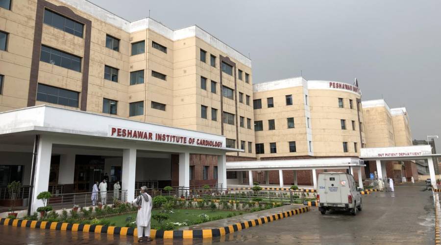 Peshawar Institute of Cardiology building with notice about potential suspension of Sehat Card services due to unpaid dues