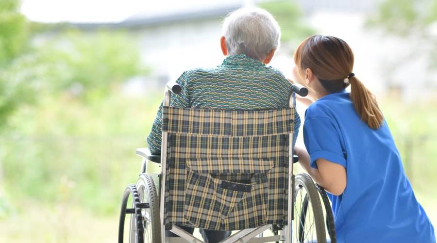 Older adult using a wheelchair safely with caregiver support and mobility tips.