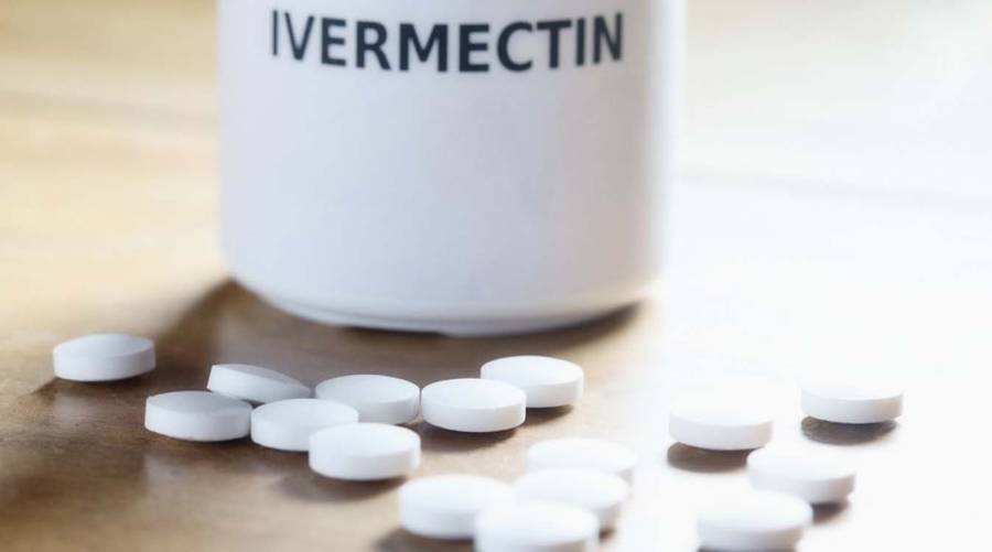 Ivermectin pills and a lab setting representing its study for cancer treatment at the National Cancer Institute.