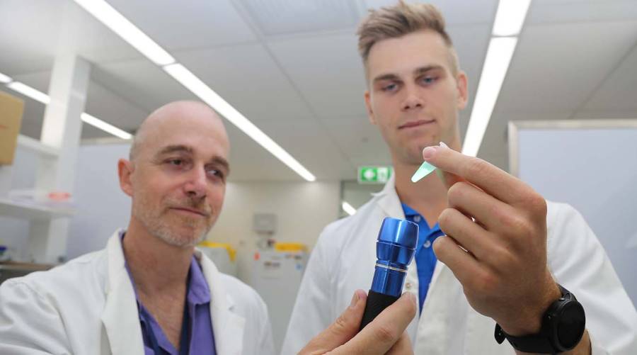 JCU scientists using a $5 protein–DNA test strip in a laboratory demonstration.