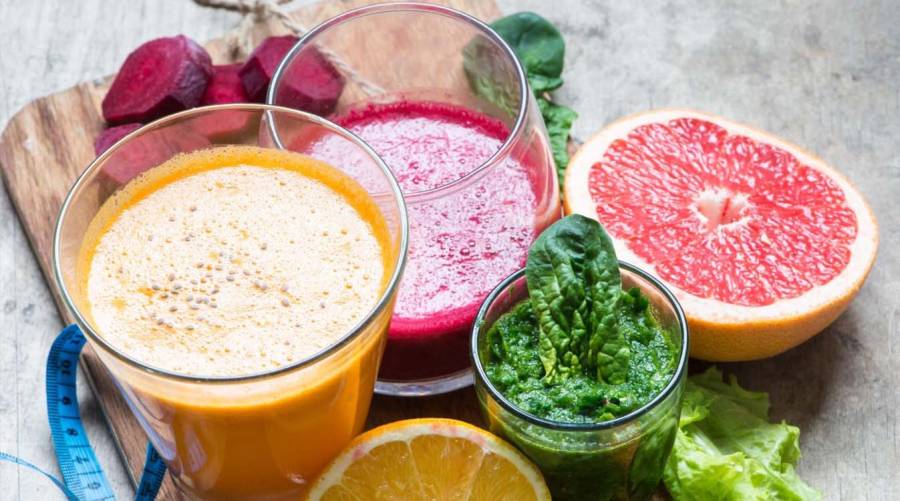 Colorful fruit and vegetable juices in glasses, highlighting healthy weight management.