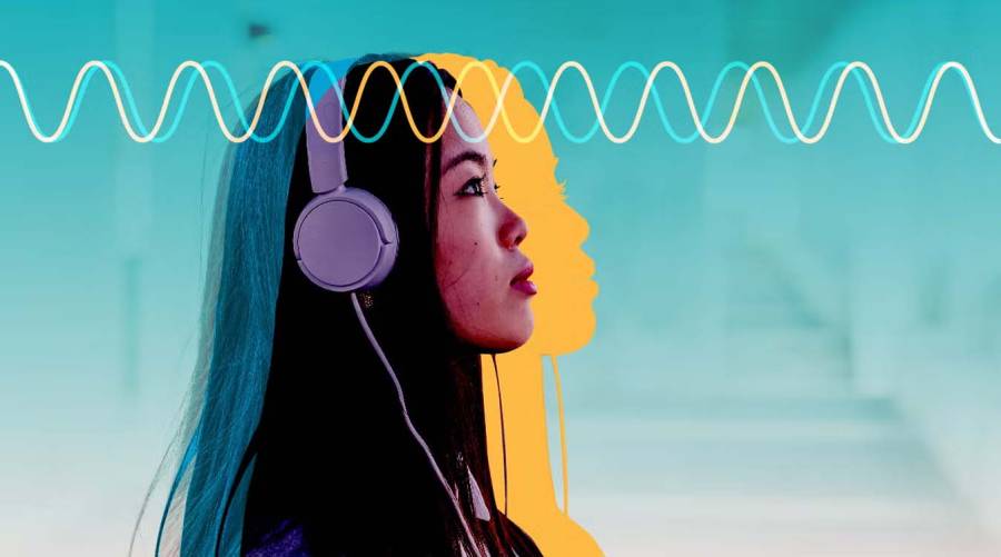 Person listening to headphones while studying brainwave-based music therapy for anxiety reduction.