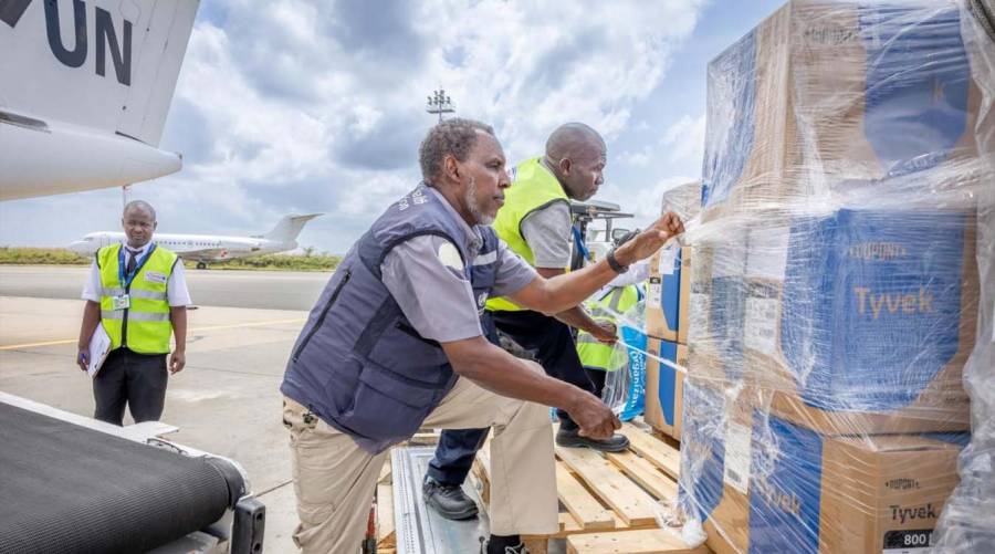 WHO health workers and emergency responders unloading medical supplies and PPE during Ebola outbreak response in Democratic Republic of Congo.