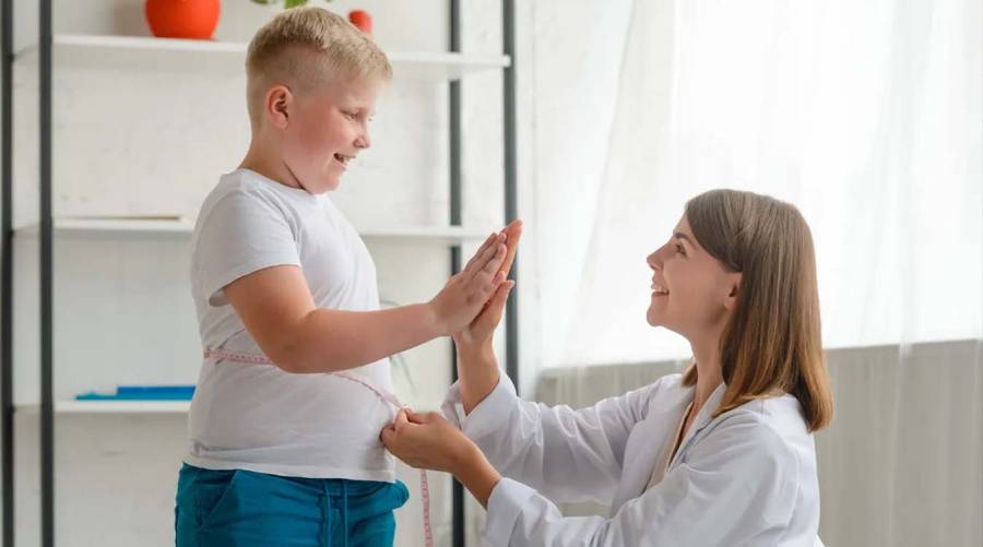 Healthcare professional discussing childhood obesity care, healthy eating and physical activity with a child and parent.