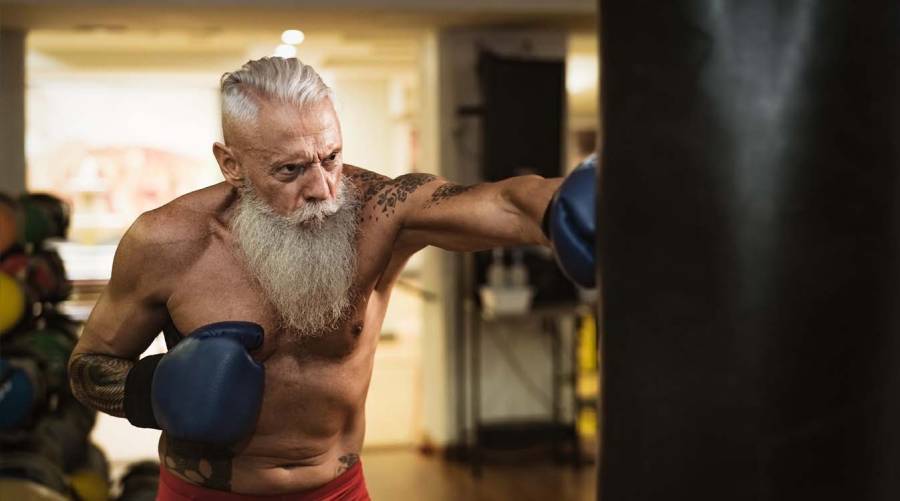 Older adult exercising in gym, illustrating healthy aging and the goal of maintaining physical function over time.
